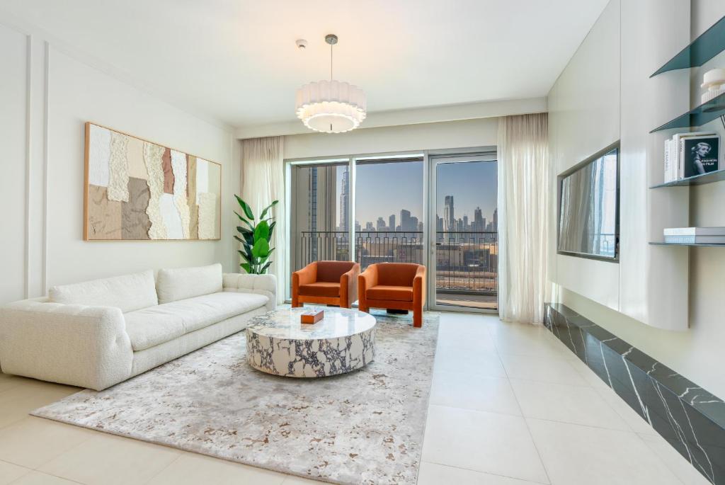 Stunning luxury apartment interior with floor-to-ceiling windows overlooking the illuminated Burj Khalifa and Dubai skyline at twilight
