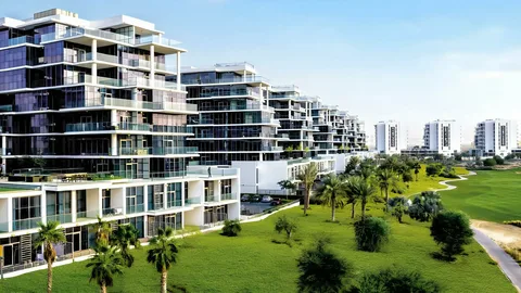 Aerial view of luxury villas with a golf course and community greenery in Damac Hills, highlighting prime real estate investment opportunities in Dubai.