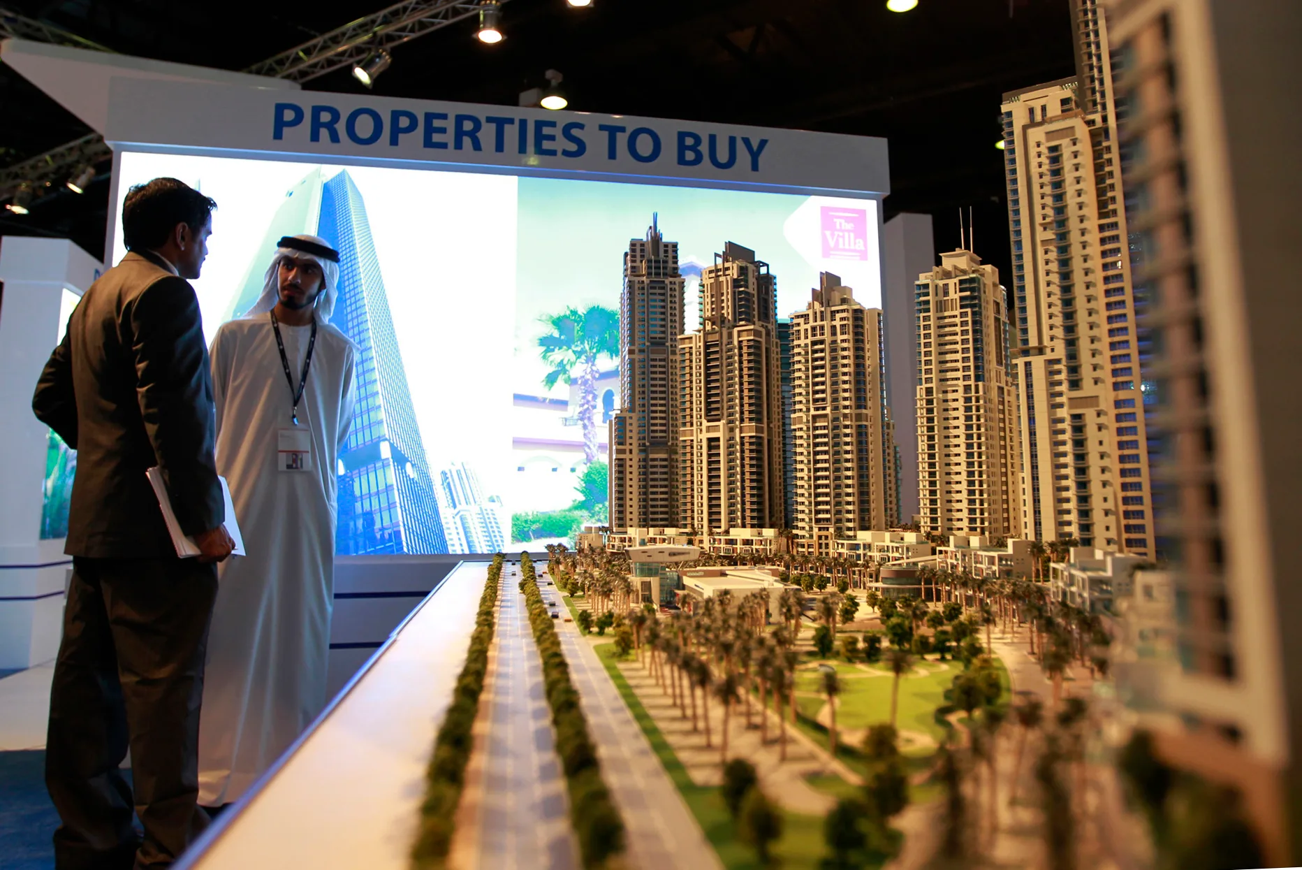 A panoramic view of Dubai's modern skyline featuring the Burj Khalifa and luxury waterfront villas, with a digital overlay of upward-trending graphs and gold coins, symbolizing the strong financial growth of the Real Estate Market.